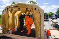 U.S. Army Sgt. Jontarius Clay (in dark hazmat suit) and U.S. Army Spc. George Hill, members of the 33rd Weapons of Mass Destruction Civil Support Team, D.C. National Guard, conduct site survey and decontamination training in vacated dormitories at Joint Base Andrews, Maryland, May 19, 2022. The training focused on using realistic settings and props to provide experience for team members. (D.C. National Guard photos by Tech. Sgt. Andrew Enriquez, 113th Wing)