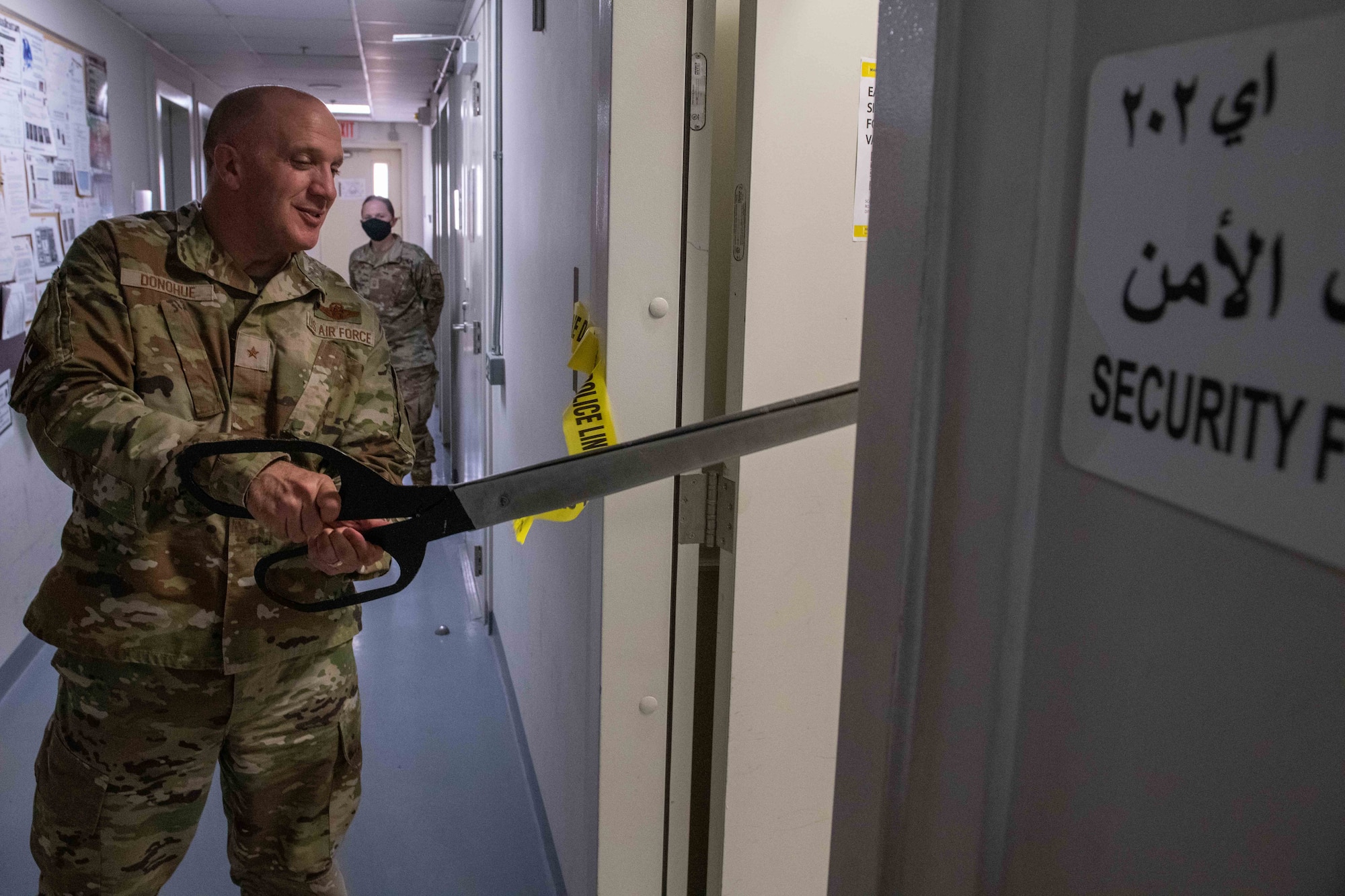 U.S. Air Force Brig. Gen. Gerald Donohue, commander of the 379th Air Expeditionary Wing, cuts ceremonial yellow tape during an equipment demonstration on Al Udeid Air Base, Qatar, May 24, 2022. The ribbon-cutting ceremony celebrates the reception of a new piece of training equipment on the installation. (U.S. Air National Guard photo by Airman 1st Class Constantine Bambakidis)