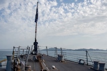 Logistics Specialist 3rd Class Matthew Haggerty, from Wayngott, Michigan, raises the Union Jack during morning colors aboard the Arleigh Burke-class guided-missile destroyer USS Jason Dunham (DDG 109), while anchored for a port visit in Durres, Albania, May 29, 2022.