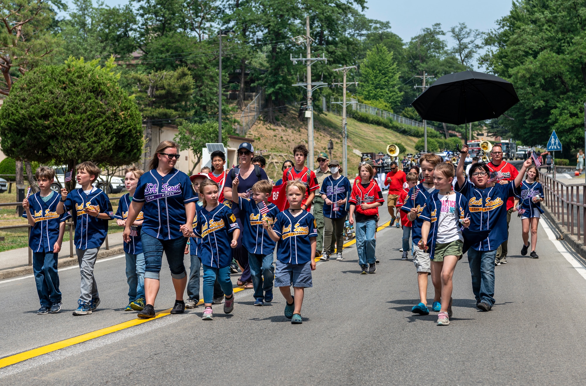 Osan Scout members walk down a street during the Armed Forces Day Parade.