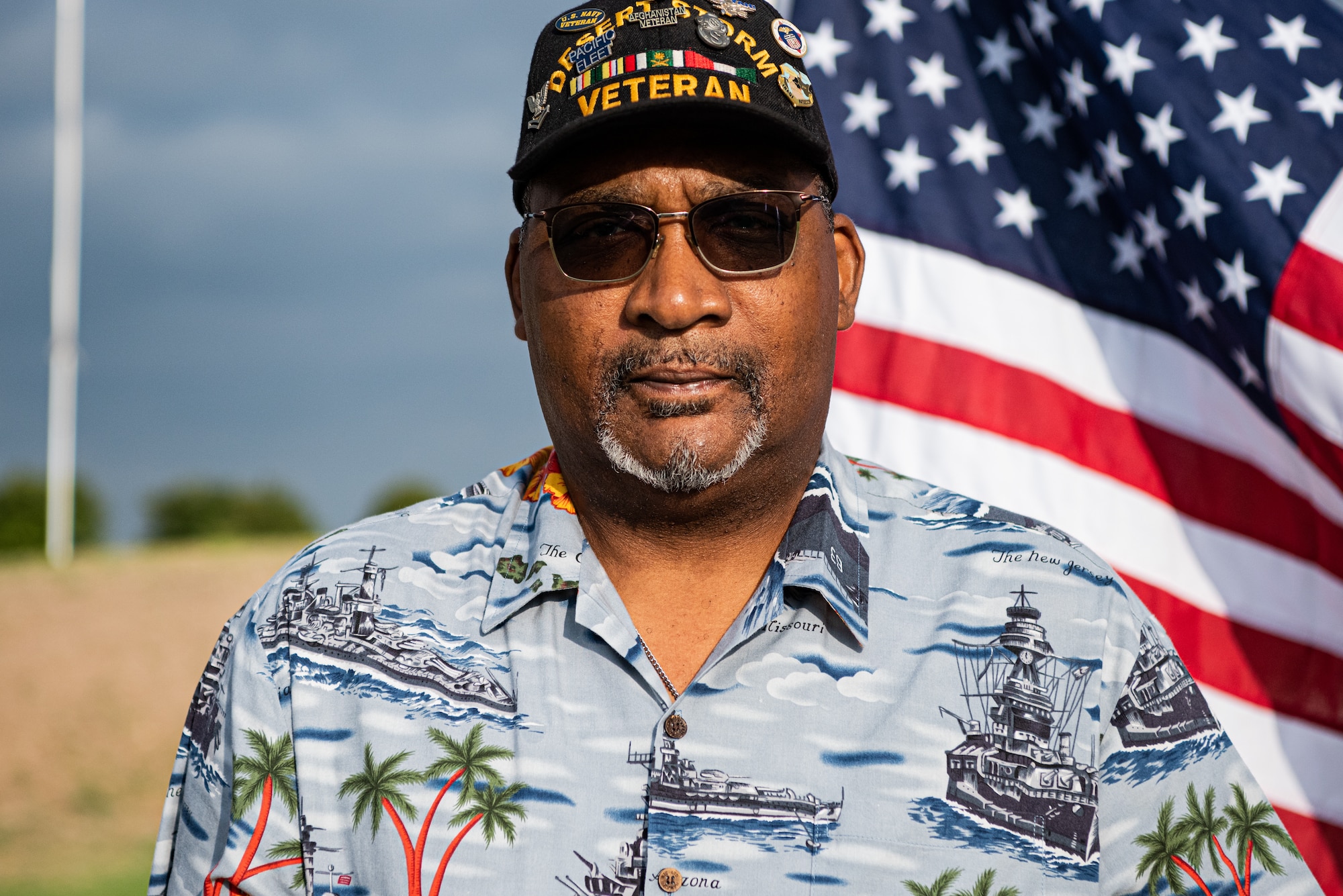 U.S. Navy Petty Officer 2nd Class (Retired) Anthony Donald stands in front of the American flag before a Memorial Day service at Lawnhaven Memorial Gardens, San Angelo, Texas, May 30, 2022. Donald served for ten years as a sea-air rescue swimmer before being medically retired. (U.S. Air Force photo by Senior Airman Michael Bowman)