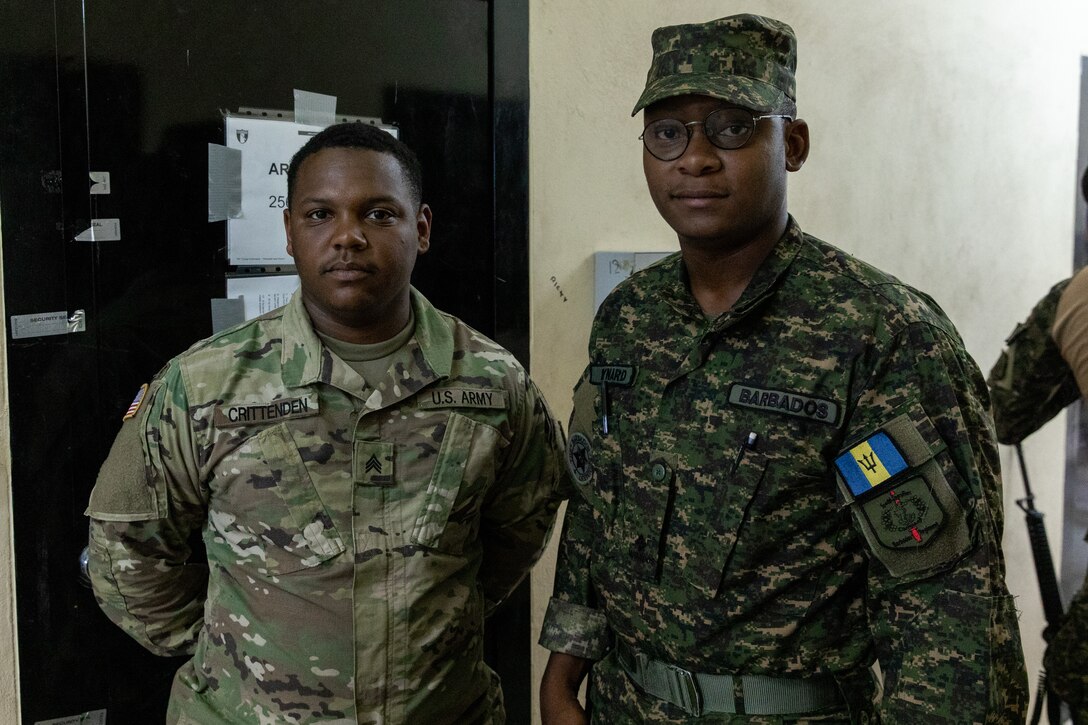 Kentucky Army National Guard Sgt. Andreus Crittenden poses for a photograph with The Barbados Defence Forces 2nd Lt. Tevin Maynard in the arms room vault on Price Barracks, Belize on May 14, 2022. Crittenden is providing armorer, logistical and maintenance support to partner nations as part of Operation Tradewinds 2022, a U.S. Southern Command mission (U.S. Army photo by Staff Sgt. Andrew Dickson).