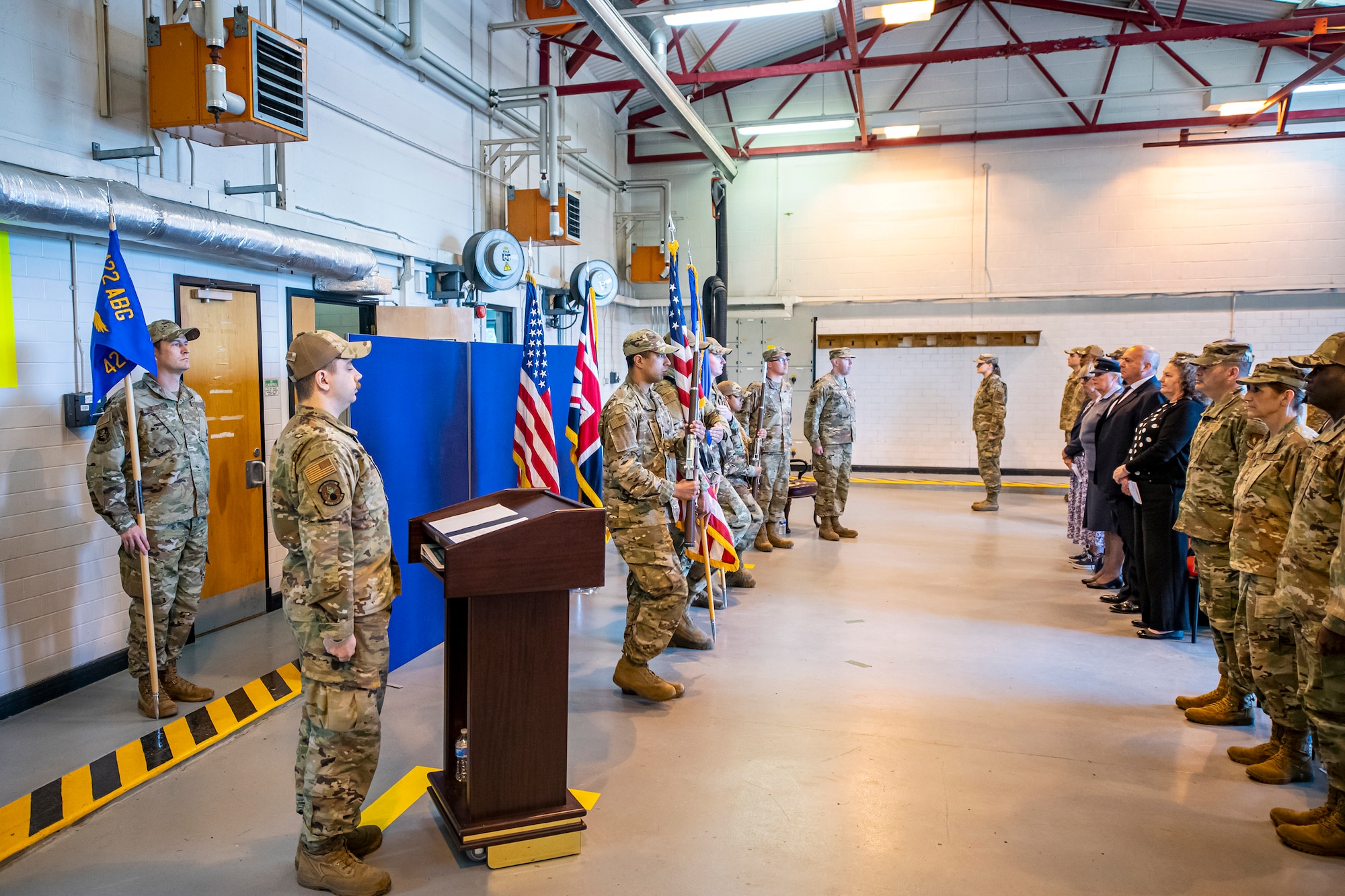 Airmen from the 501st Combat Support Wing stand at attention prior to the playing of the national anthem during a change of command ceremony at RAF Welford, England, May 26, 2022. The ceremony is a military tradition that represents a formal transfer of a unit’s authority and responsibility from one commander to another. (U.S. Air Force photo by Staff Sgt. Eugene Oliver)