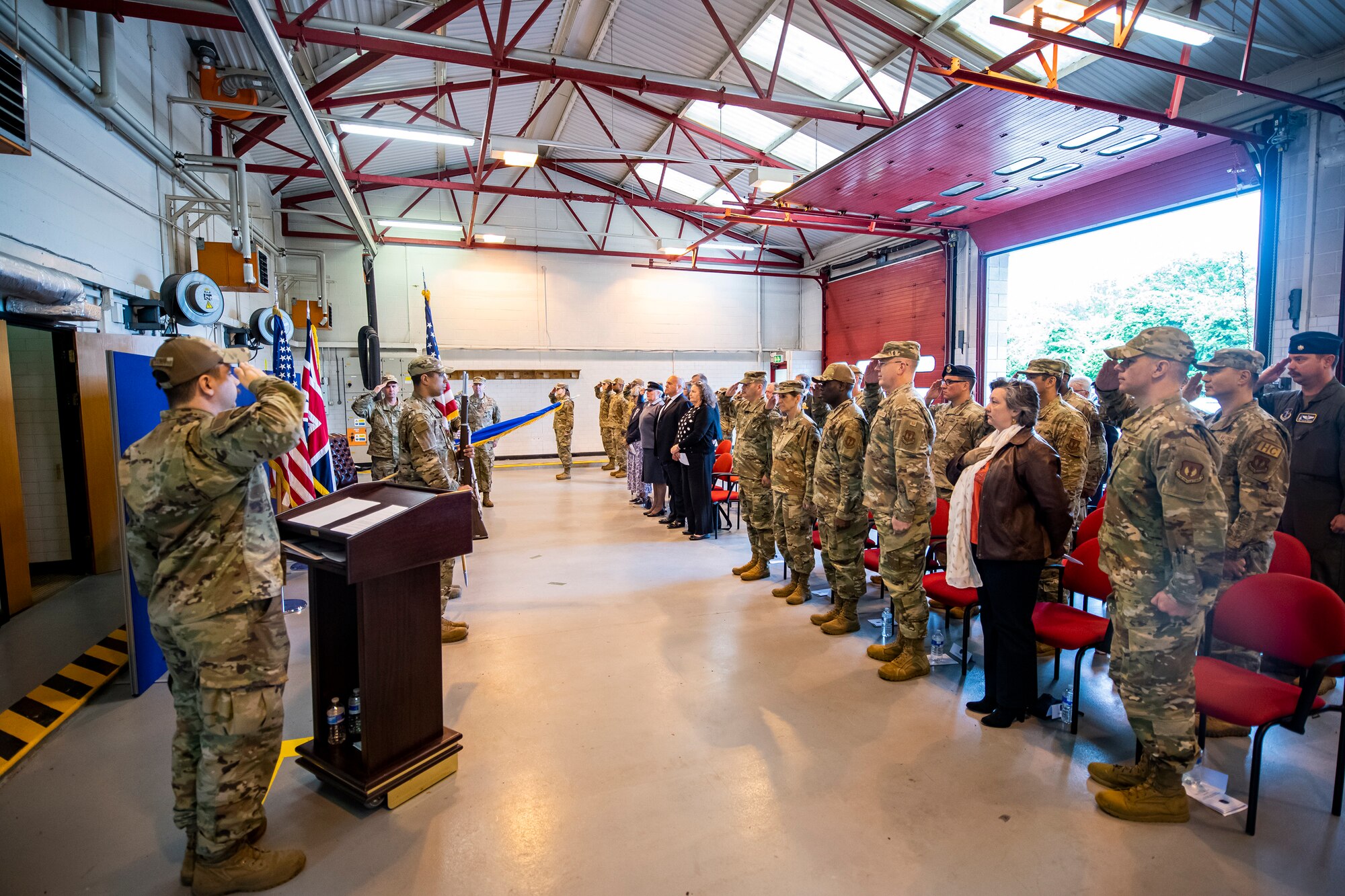 Airmen from the 501st Combat Support Wing salute during the playing of the national anthem during a change of command ceremony at RAF Welford, England, May 26, 2022. The ceremony is a military tradition that represents a formal transfer of a unit’s authority and responsibility from one commander to another. (U.S. Air Force photo by Staff Sgt. Eugene Oliver)