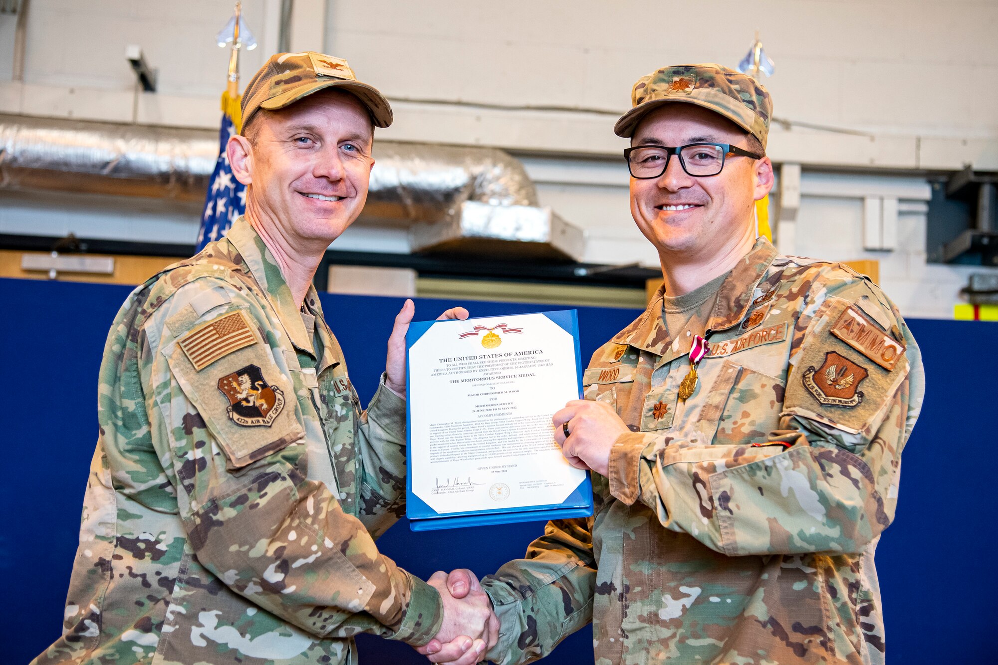 U.S. Air Force Col. Jon T. Hannah, left, 422d Air Base Group commander, presents a meritorious service medal to Maj. Christopher Wood, 420th Munitions Squadron outgoing commander, during a change of command ceremony at RAF Welford, England, May 26, 2022. During his command Wood was responsible for all munitions operations maintaining USAFE’s second largest weapons stockpile valued at $403 million in war reserve material. (U.S. Air Force photo by Staff Sgt. Eugene Oliver)