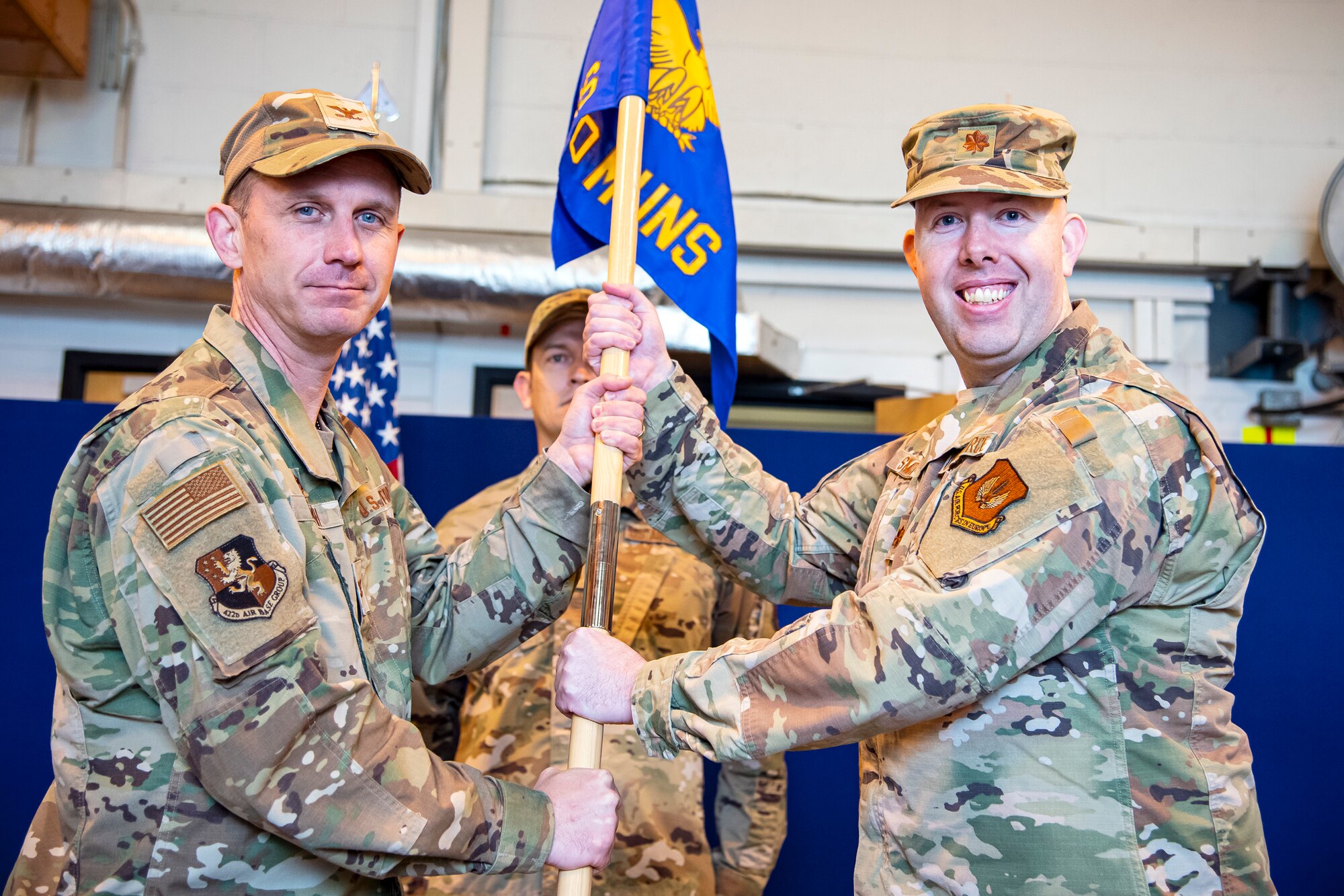 U.S. Air Force Maj. Preston Smith, right, 420th Munitions Squadron incoming commander, receives the 420th MUNS guidon from Col. Jon T. Hannah, 422d Air Base Group commander, during a change of command ceremony at RAF Welford, England, May 26, 2022. Prior to assuming command of the 420th MUNS, Smith served as the director of operations for the 509th Maintenance Squadron, Whiteman Air Force Base, Missouri. (U.S. Air Force photo by Staff Sgt. Eugene Oliver)