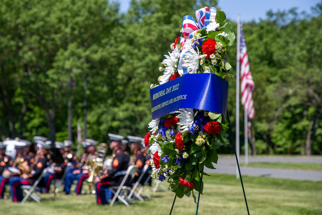 A decorative wreath on display outside, covered with flowers and ribbons for Memorial Day.