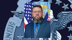 Official portrait of Heath Buswell DLA Disposition Services Mid-America with flags in the background.