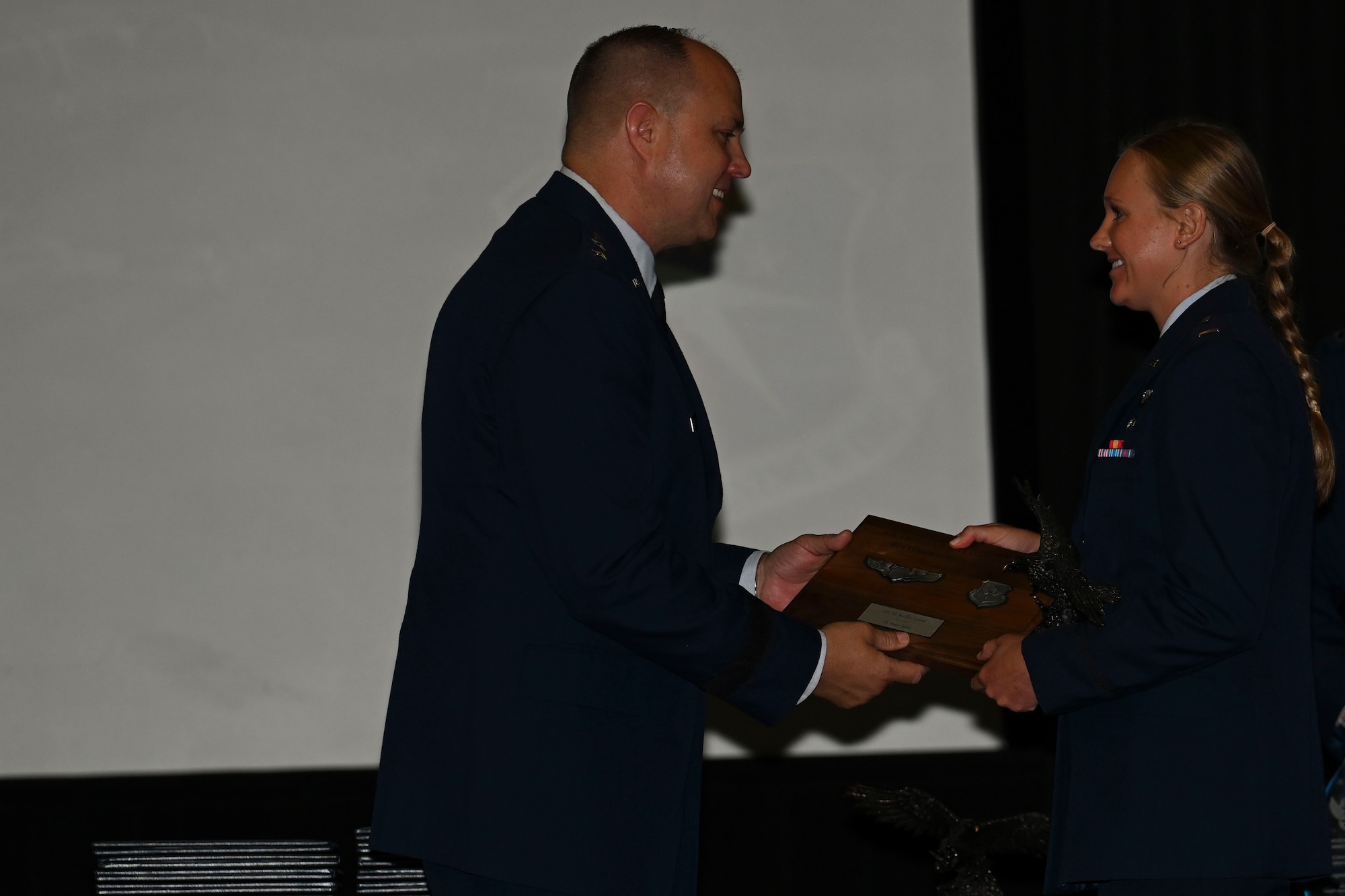 U.S. Air Force Maj. Gen. John Nichols, Global Power Programs, Office of the Assistant Secretary of the Air Force for Acquisition, Technology and Logistics, director, the Pentagon, Arlington, Virginia, presents the AETC Commander’s Trophy and Honor Graduate plaque to 1st Lt. Kelly Grier, May 26, 2022, on Columbus Air Force Base, Miss. Grier was one of three graduates recognized for excelling in both academics and leadership. (U.S. Air Force photo by Airman 1st Class Jessica Haynie)