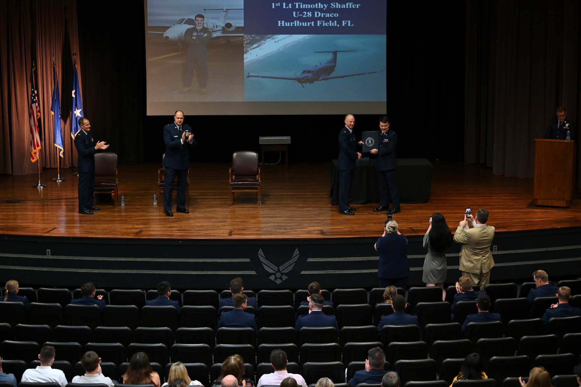 Family and friends of the graduates gather at the front of the stage to capture the perfect “hero shot”, of their graduate, May 26, 2022, on Columbus Air Force Base, Miss. Class 22-10 graduated with 22 new military pilots. (U.S. Air Force photo by Airman 1st Class Jessica Haynie)