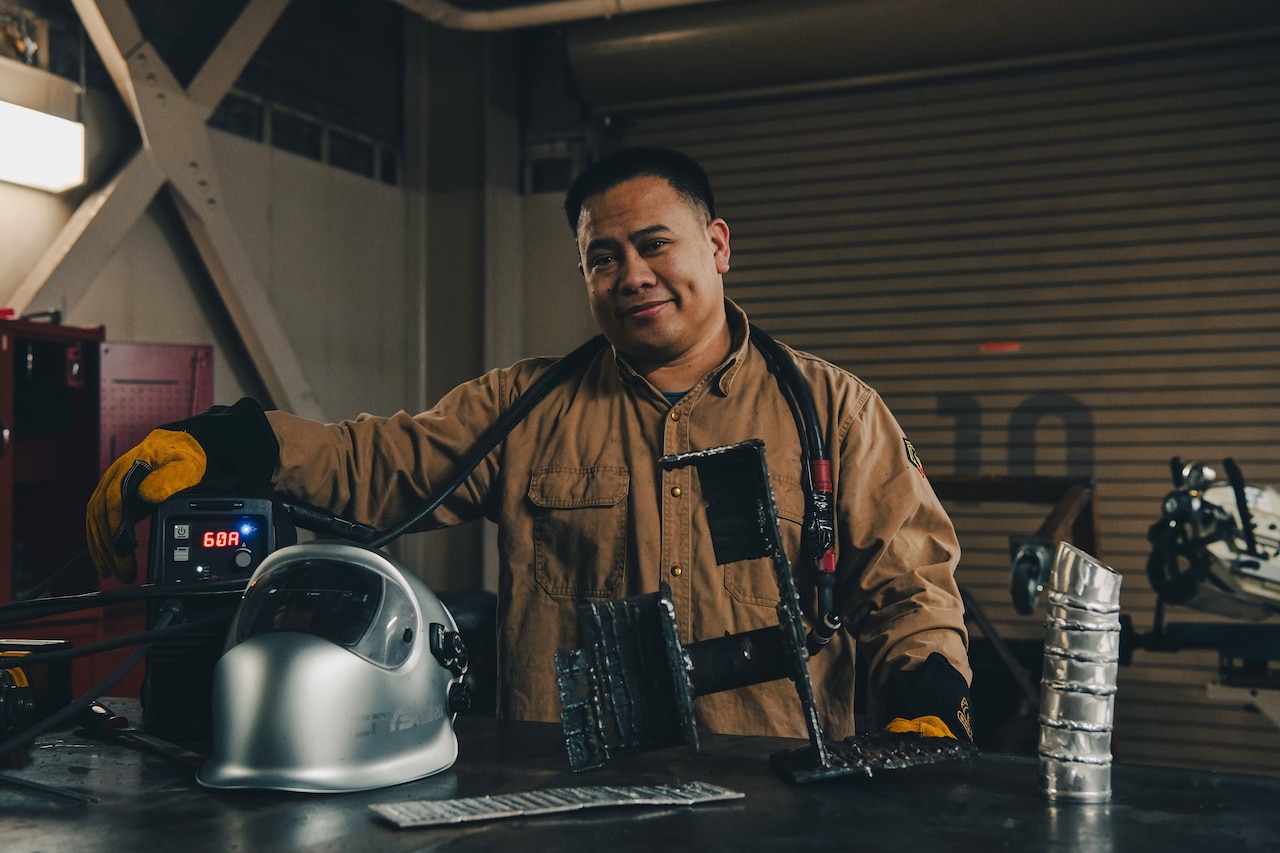 A sailor stands for a photo in a hobby shop.