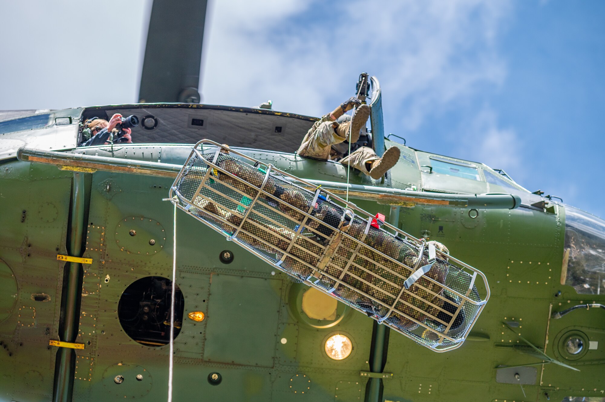 Airman 1st Class Courage Krueger, 341st Contracting Squadron contracting apprentice, is lifted into a UH-N1 Huey during a search and rescue exercise May 24, 2022, over the Highwood Mountains near Great Falls, Mont.