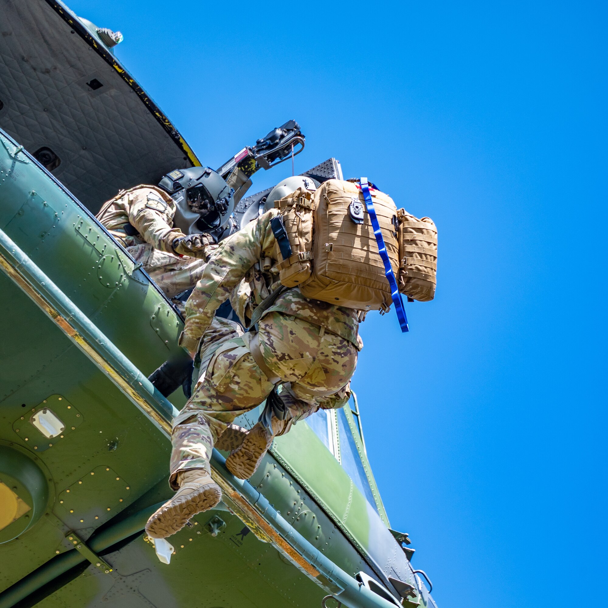 Staff Sgt. Chase Rose, 40th Helicopter Squadron flight engineer, helps Capt. Noah Russell, 341st Operational Medical Readiness Squadron flight medic, into a UH-N1 Huey during a search and rescue exercise May 24, 2022, over the Highwood Mountains near Great Falls, Mont.