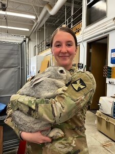 Minnesota National Guard Spc. Asia Enger holds a giant rabbit near Kodiak, Alaska, where 43 Guard members with the 204th Medical Company Area Support Company mobilized in early May to support Arctic Care 2022.