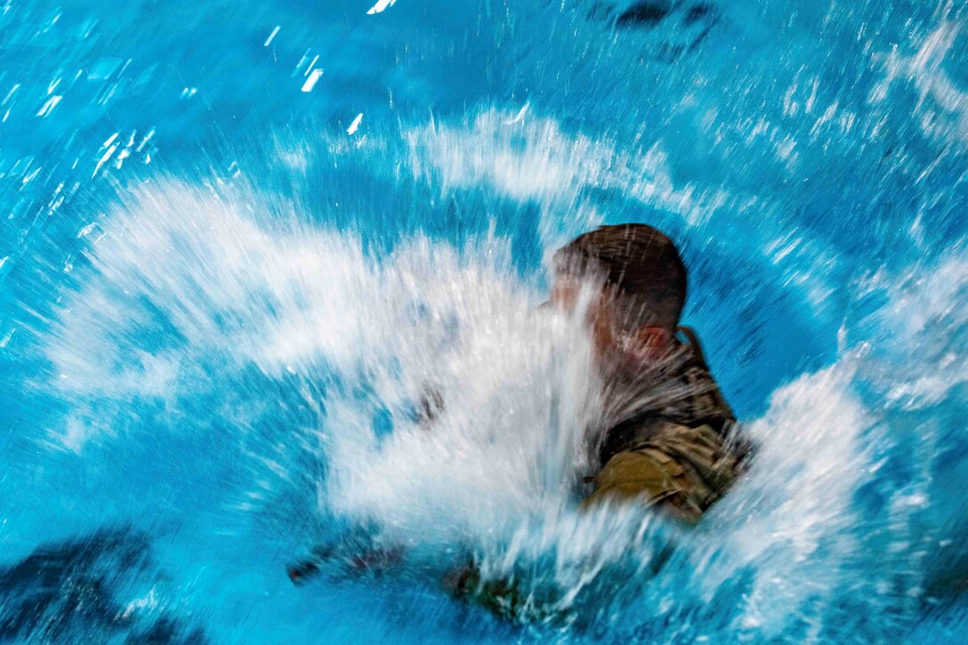 A soldier dives into a pool.