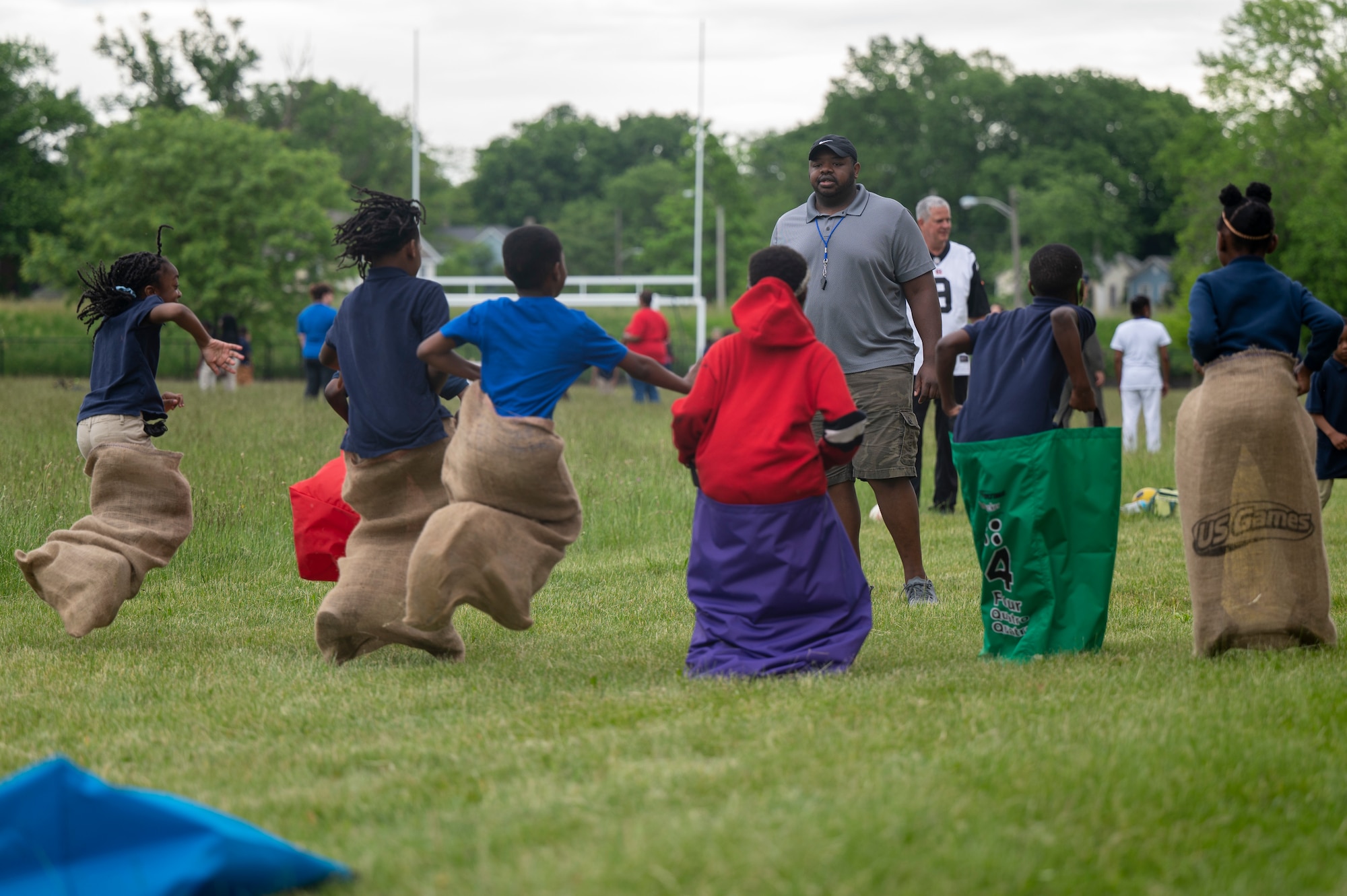 Deshaun Dilworth, a volunteer from the Air Force Life Cycle Management Center Special Programs Division, officiates a sack race during a field day to mark the end of the school year at Edison Elementary School May 25, 2022. Members of the Special Programs Division helped host the field day by setting up and running outdoor activities for the students to enjoy on their last day of school. (U.S. Air Force photo by Tech. Sgt. Matthew B. Fredericks)
