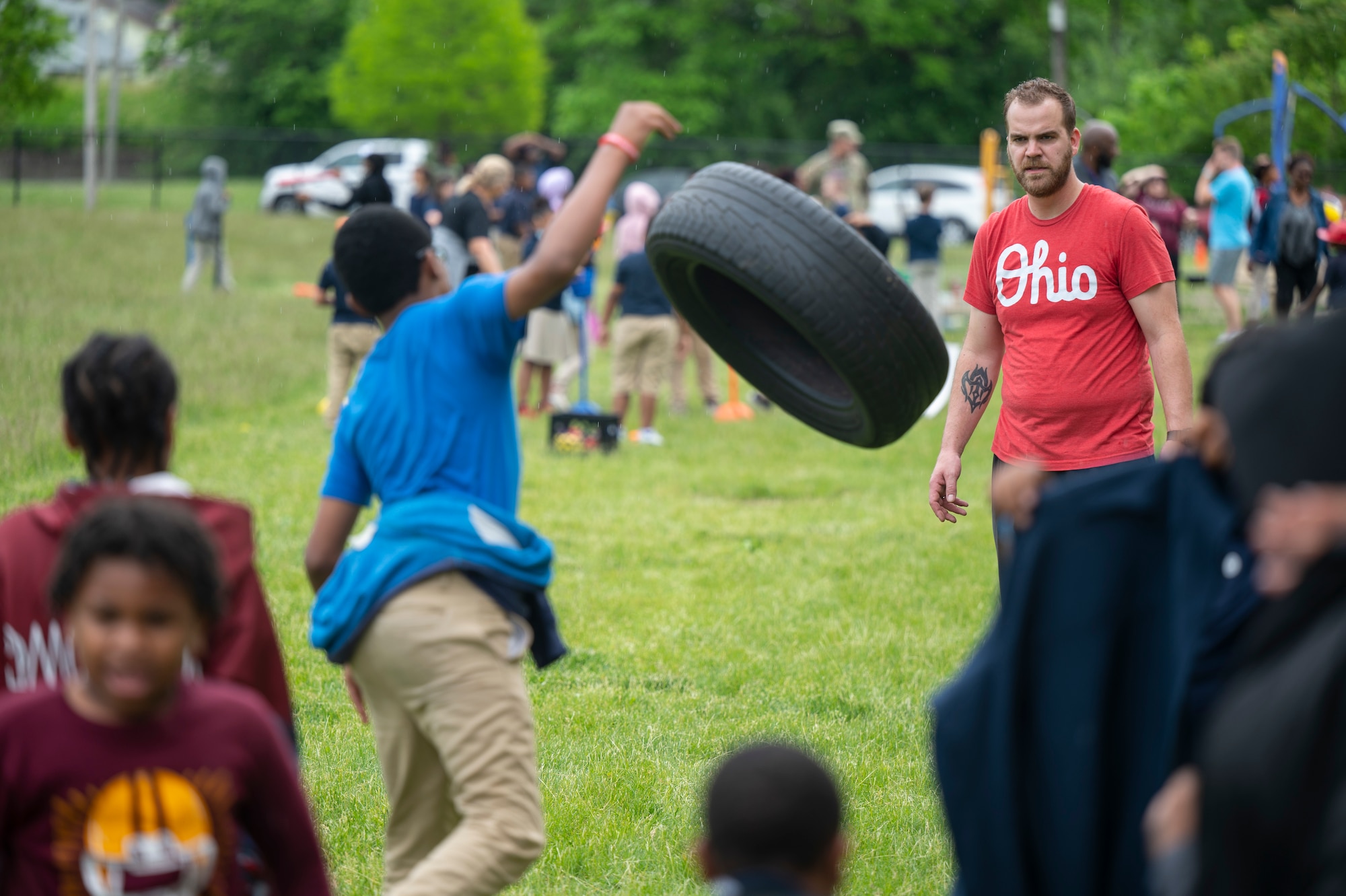David Andrejcio, a volunteer from the Air Force Life Cycle Management Center Special Programs Division, runs a tire toss and roll event during a field day to mark the end of the school year at Edison Elementary School May 25, 2022. Members of the Special Programs Division helped host the field day by setting up and running outdoor activities for the students to enjoy on their last day of school. (U.S. Air Force photo by Tech. Sgt. Matthew B. Fredericks)