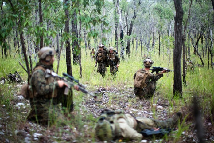 A U.S. Marine with 3d Platoon, Lima Company, 3d Battalion, 7th Marine Regiment, Ground Combat Element, Marine Rotational Force-Darwin 22, helps a simulated casualty off of the battlefield during a simulated combat defense as part of exercise Southern Jackaroo 22 at Shoalwater Bay Training Area, May 21, 2022. Southern Jackaroo is a multilateral exercise carried out by Marines with MRF-D, the Australian Army and Japan Ground Self-Defense Force soldiers, focusing on live-fire and combined arms training. (U.S. Marine Corps Photo by Cpl. Cedar Barnes)