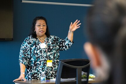 Adele Borders, U.S. Army Financial Management Command Military Pay Operations branch manager, speaks to USAFMCOM Army Military Pay Office directors and supervisors during an AMPO leadership forum at the Maj. Gen. Emmett J. Bean Federal Center in Indianapolis May 12, 2022. Throughout the three-day forum, subject matter experts from USAFMCOM, the Defense Finance and Accounting Service, and other U.S. Army organizations covered a variety of topics including military pay operations, human resources, debt and claims, SmartVoucher for permanent change of station moves, fraud, ethics, and Army-specific functions. (U.S. Army photo illustration by Mark R. W. Orders-Woempner)