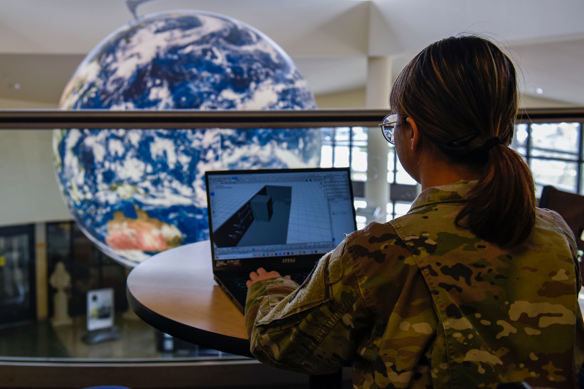 U.S. Air Force Airman 1st Class Tanjai Ploykao works on a 3D software system.