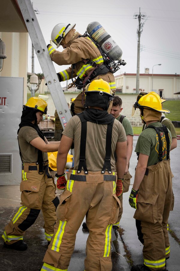 U.S. service members with Headquarters and Headquarters Squadron, Marine Corps Air Station Futenma, Marine Corps Installations Pacific, monitor a ladder climbing task during a firefighter Physical Ability Test on Marine Corps Air Station Futenma, Okinawa, Japan, May 4, 2022. The firefighters’ Physical Ability Test is a tool used to measure how effective a Marine is while performing multiple tasks over a set period. The test consists of 10 tasks that evaluate cardiovascular and strength performance. (U.S. Marine Corps photo by Lance Cpl. Jonathan Beauchamp)