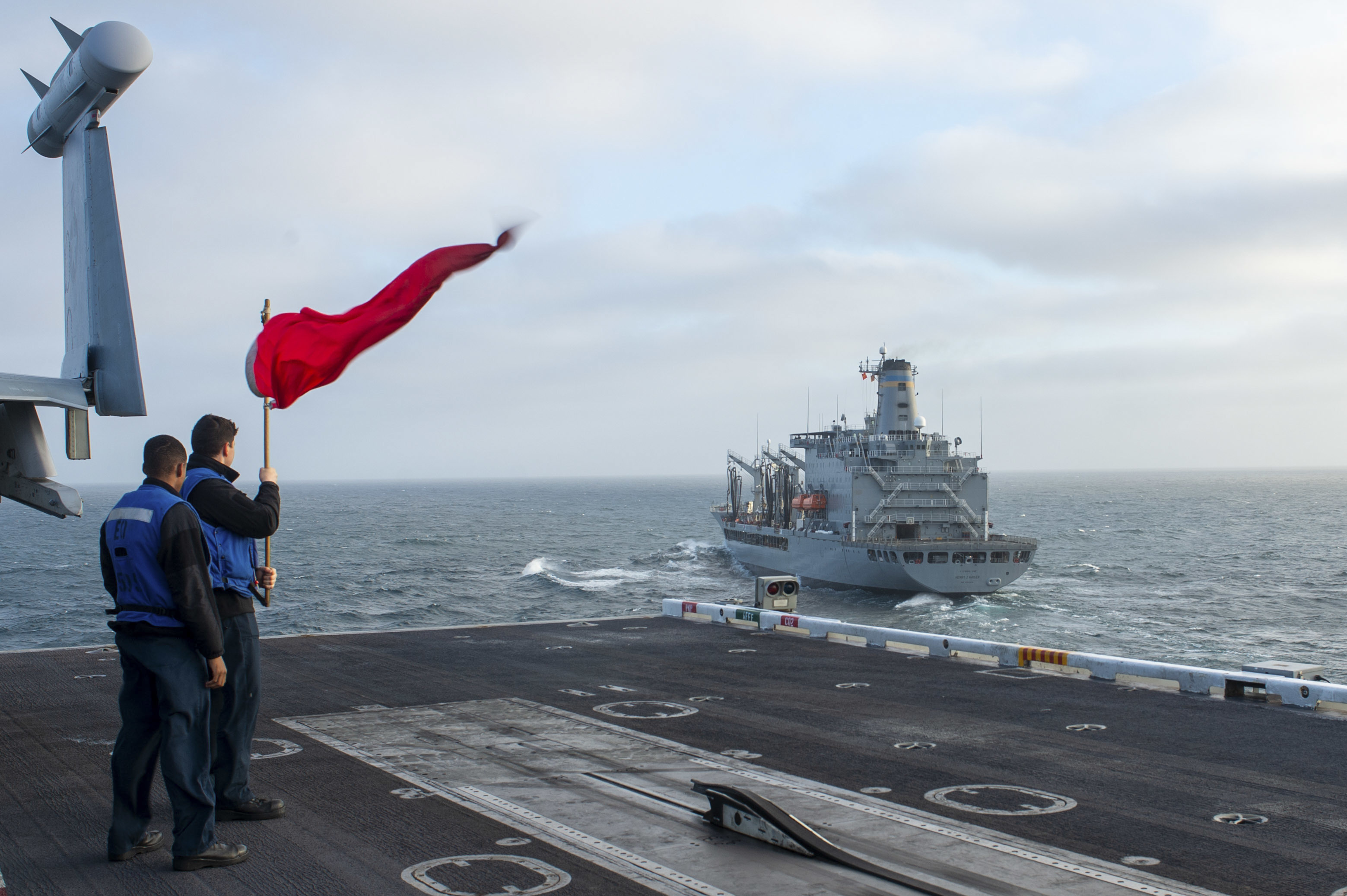 Sailors onboard the aircraft carrier USS Nimitz (CVN 68) signal the Military Sealift Command Henry J. Kaiser-class fleet replenishment oiler USNS Henry J. Kaiser (T-AO-187) for a replenishment at sea.