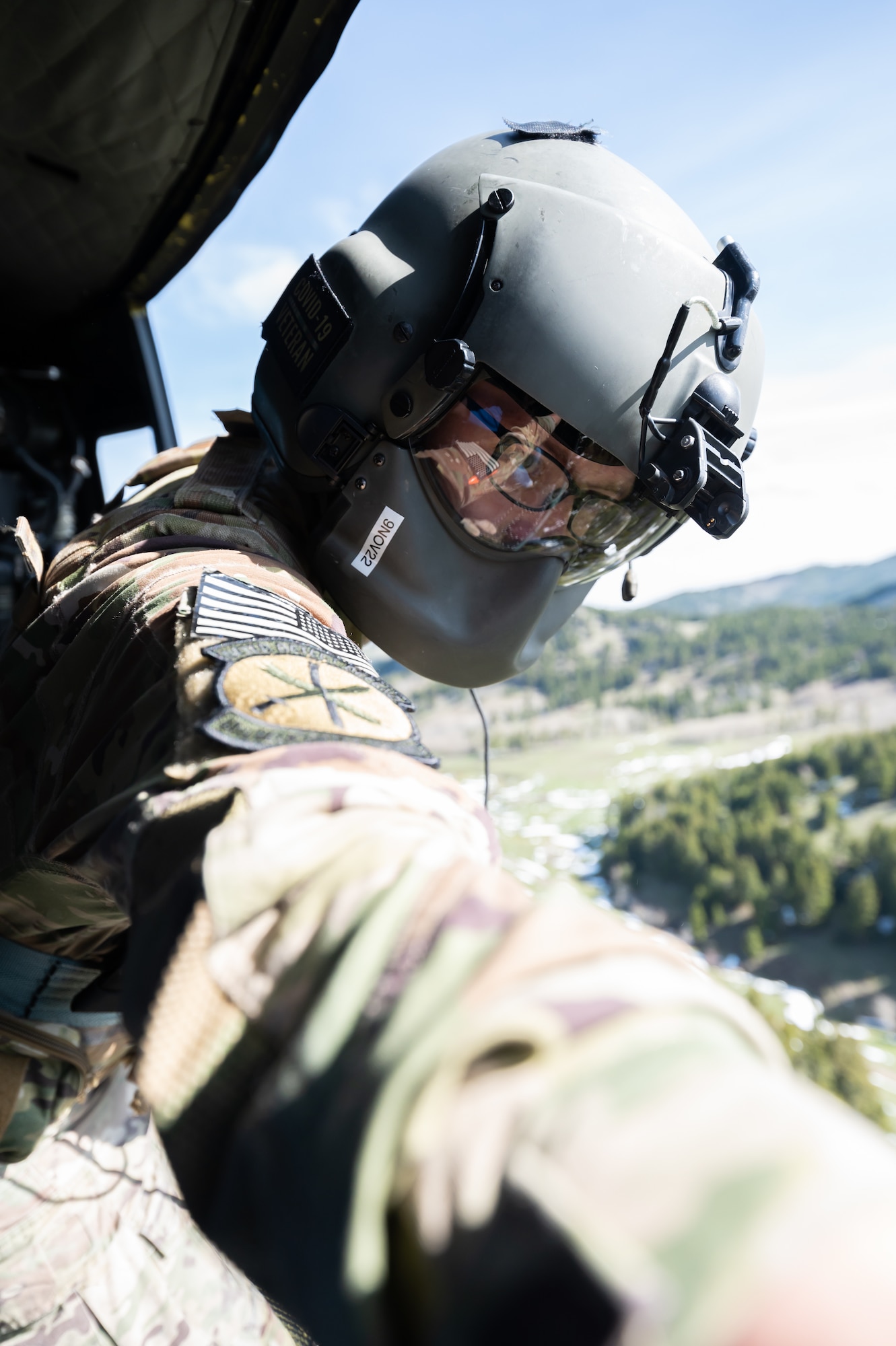 Staff Sgt. Chase Rose, 40th Helicopter Squadron flight engineer, opens the side door of a UH-1N Huey helicopter May 24, 2022, above the Highwood Mountains near Great Falls, Mont.