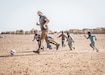 A U.S. Soldier plays soccer with children