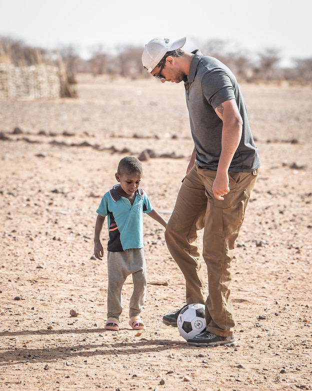 A U.S. Soldier plays soccer with a child at Attimick, Niger