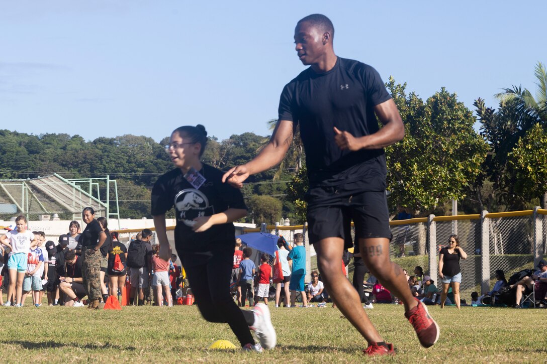 U.S. Marine Corps Cpl. Deandre K. Strong, an administrative specialist with Headquarters and Support Battalion, Marine Corps Installations Pacific, guides military children through the combat fitness test during Kid’s Warrior Day on Camp Foster, Okinawa, Japan, Oct. 28, 2022. Kid’s Warrior Day is an event that gives the opportunity for military children to experience the service requirements their parents needed to pass in order to be U.S. Marines. The event featured a mock CFT, close-order drill, a toy gun rifle range, and Marine Corps Martial Arts Program techniques. (U.S. Marine Corps photo by Sgt. Christopher D. Thompson)