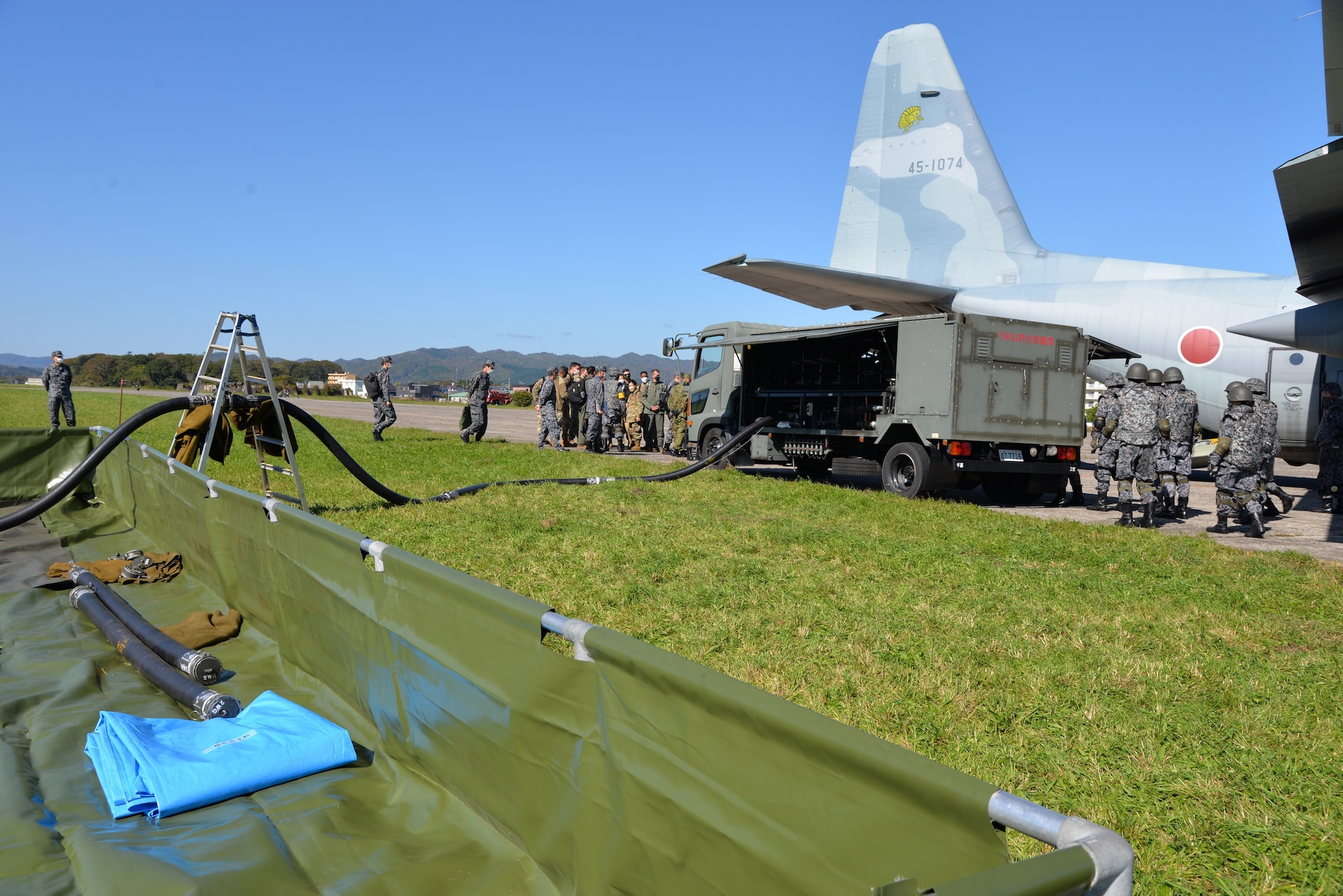 Members from 5th Air Force and the 515th Air Mobility Command watch as Japan Air Self-Defense Force (Koku Jieitai) simulate refueling an aircraft at Yakumo Sub Base, Japan, Oct. 13, 2022. U.S. service members went to Yakumo Sub Base to learn how to better integrate with JASDF during a real-world contingency. (Courtesy photo from JASDF)