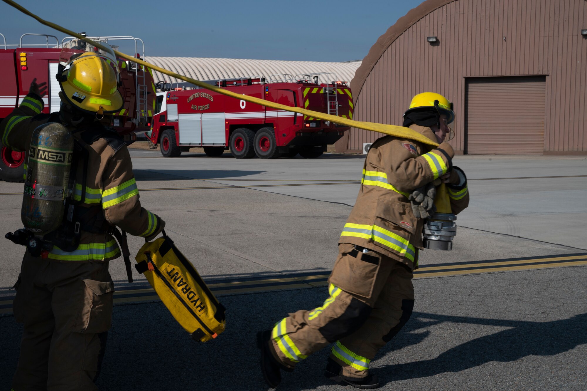 U.S. Air Force 51st Civil Engineer Squadron firemen unravel a hose during a fire training event as part of Vigilant Storm 23 at Osan Air Base, Republic of Korea, Oct. 31, 2022.