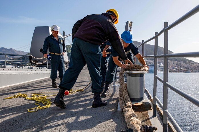 Sailors assigned to the Ticonderoga-class guided-missile cruiser USS Leyte Gulf (CG 55) secure line from a tugboat as the ship pulls into Dubrovnik, Croatia, for a scheduled port visit, Oct. 31, 2022.