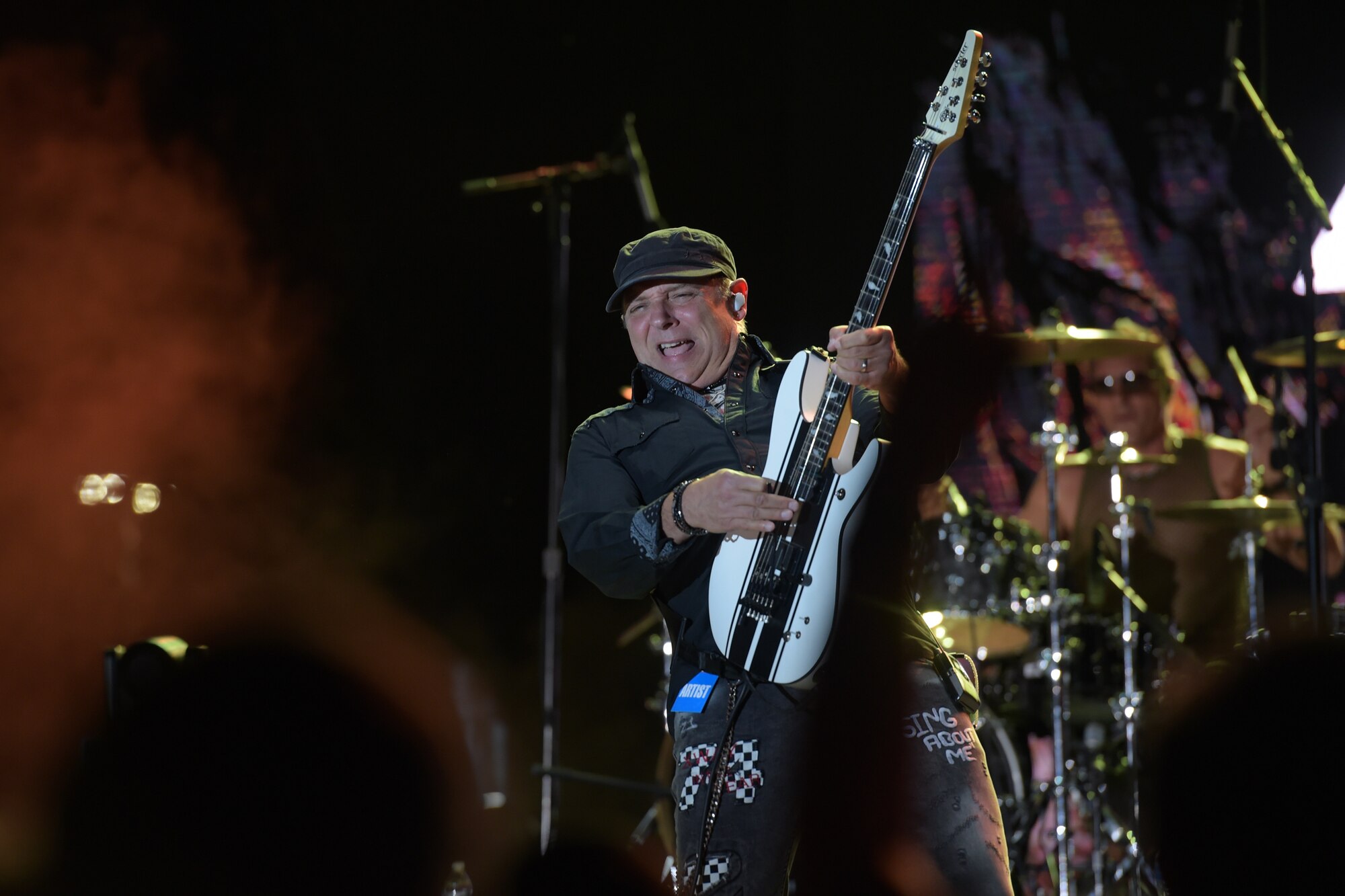 man smiling and playing guitar