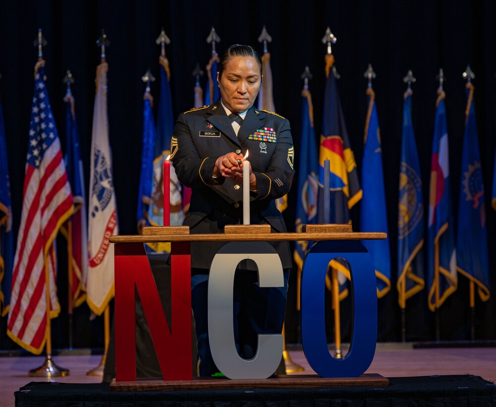 U.S. Army Sgt. 1st Class Maria Araceli Grageda Borja, assigned to McDonald Army Health Center, lights the first candle during Joint Noncommissioned Officer Induction Ceremony