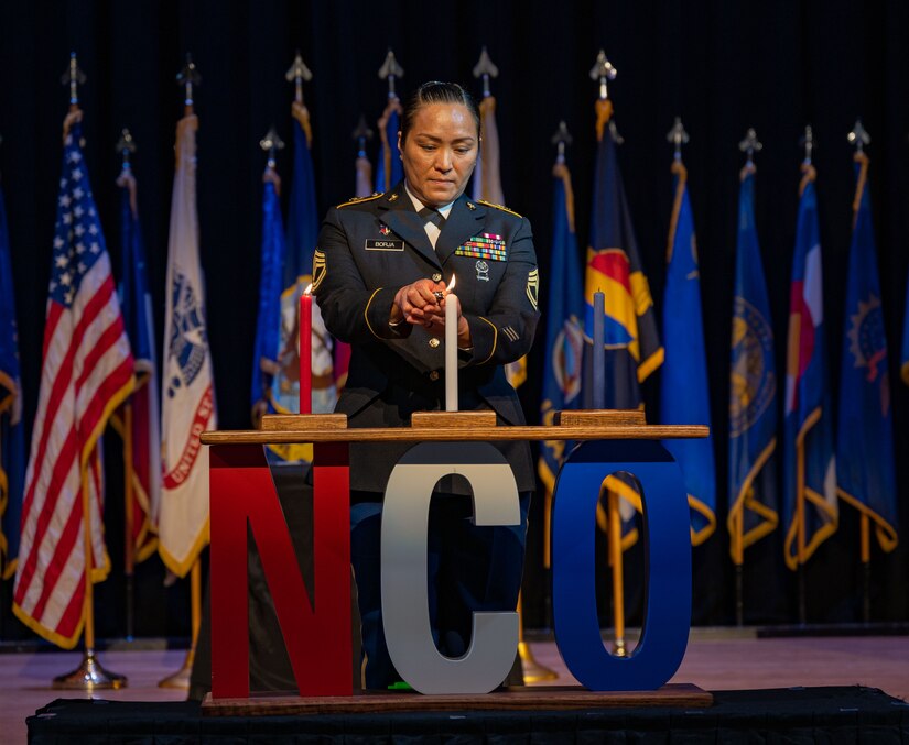 U.S. Army Sgt. 1st Class Maria Araceli Grageda Borja, assigned to McDonald Army Health Center, lights the first candle during Joint Noncommissioned Officer Induction Ceremony
