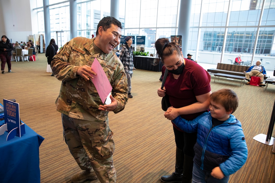 Tech. Sgt. Blassi Shoogukwruk, a C-17 Globemaster III crew chief with the 176th Aircraft Maintenance Squadron receives artwork from a young participant in the Elder and Native Youth conference held by the First Alaskans Institute in Anchorage, Alaska, Oct. 18, 2022. The conference gives Alaska Native youth opportunities to meet with elders in their communities and learn how to advocate for themselves and their people as well as connect with others. (Alaska National Guard photo by Staff Sgt. Katie Mazos-Vega)