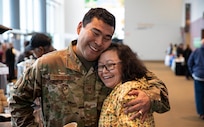 Tech. Sgt. Blassi Shoogukwruk, a C-17 Globemaster III crew chief with the 176th Aircraft Maintenance Squadron hugs his cousin, Patti Oksoktaruk Lillie during the First Alaskans Institute Elder and Native Youth conference held in Anchorage, Alaska, Oct. 18, 2022. The conference gives Alaska Native youth opportunities to meet with elders in their communities and learn how to advocate for themselves and their people as well as connect with others. (Alaska National Guard photo by Staff Sgt. Katie Mazos-Vega)