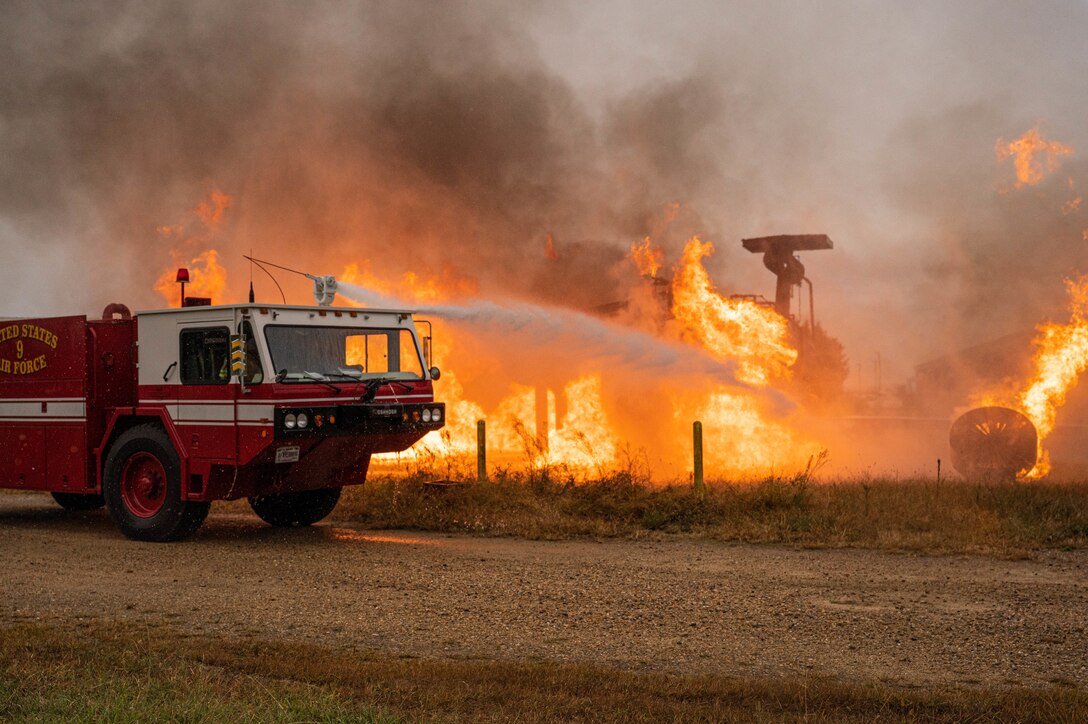 An Oshkosh P-19 Aircraft Rescue and Firefighting vehicle douses the flames during a fire exercise on the small aircraft trainer at Joint Base Langley-Eustis, Virginia, Oct. 13, 2022.