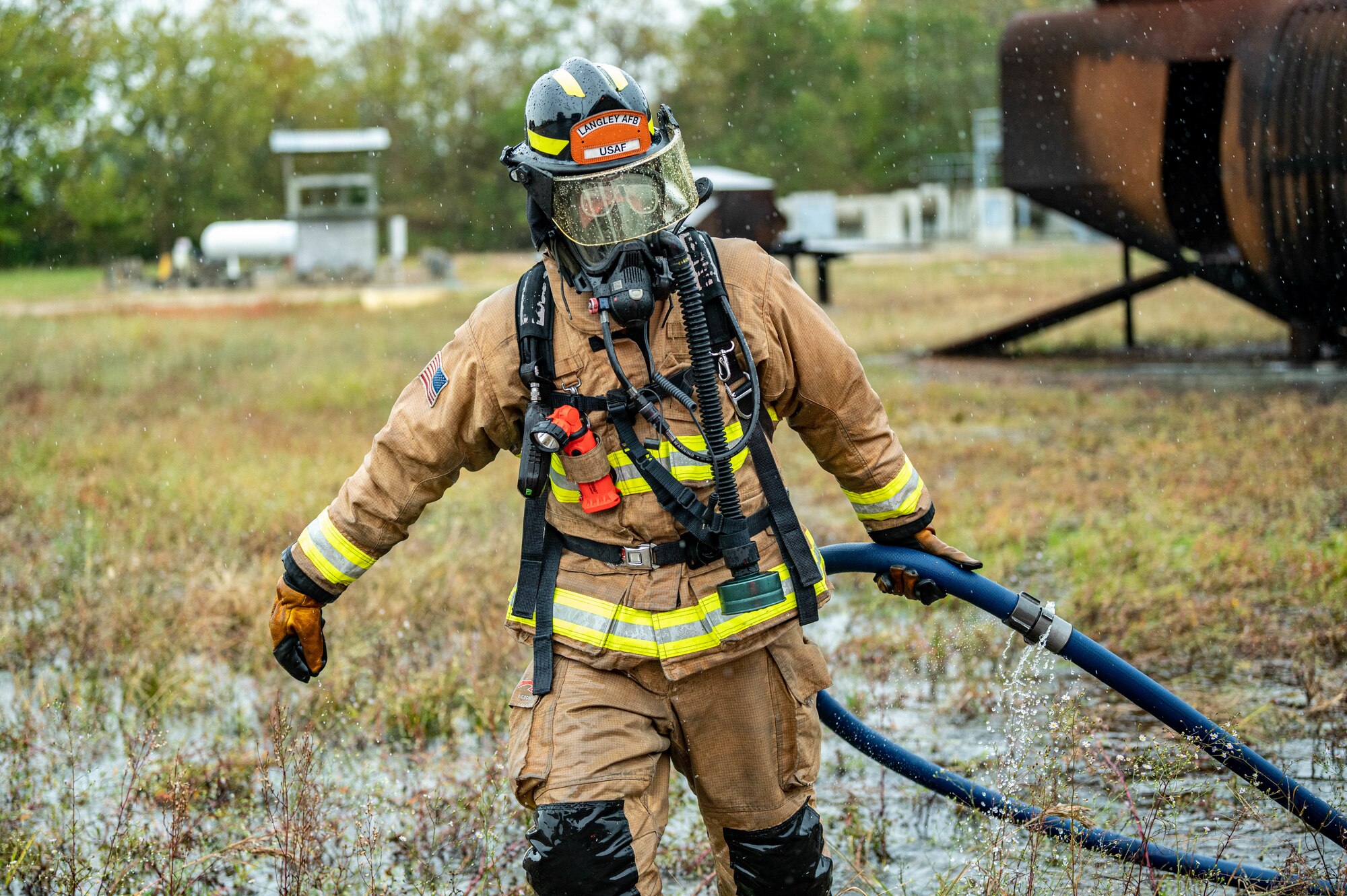 - U.S. Air Force Senior Airman Christopher Parks, 633d Civil Engineer Squadron firefighter, wades through water and tall grass to put the hose away after taking part in successfully putting out the fire on a small aircraft trainer during an exercise at Joint Base Langley-Eustis, Virginia, Oct. 13, 2022.