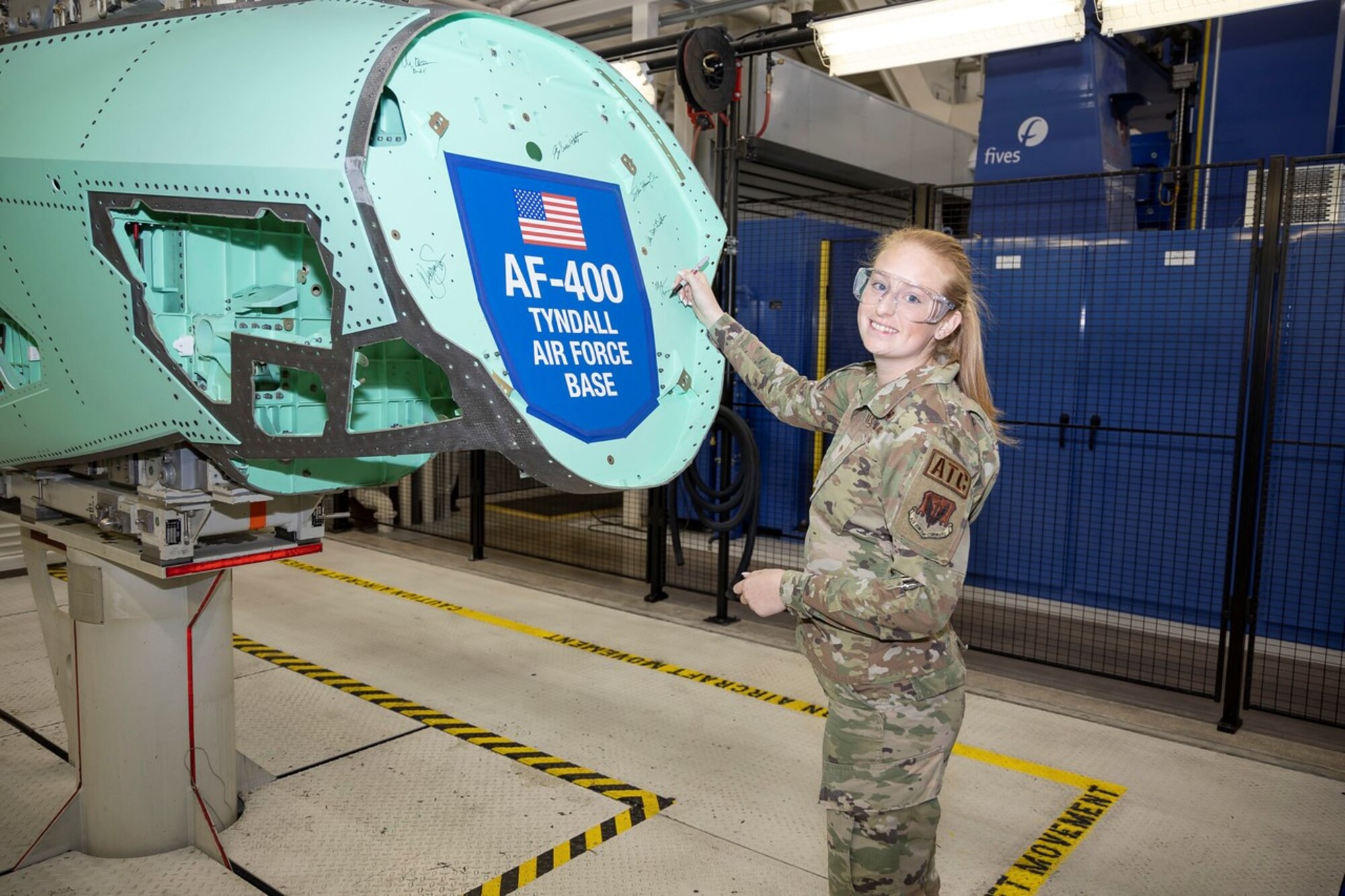 U.S. Air Force Senior Airman Morgan Reid, 325th Operations Support Squadron air traffic controller, signs an F-35A Lightning II airframe structural component at the Lockheed Martin factory in Fort Worth, Texas, Oct. 20, 2022.