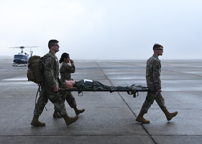 2nd Lt. Dylan Thomas, 316th Health Care Operations Squadron intensive care unit nurse (left), Capt. Dominique Hunsberger, 316th HCOS intensive care unit nurse (center), and Capt. Nicholas Lahvic, 316th Surgical Operations Squadron anesthesiologist, carry a simulation manikin during a medical training at Joint Base Andrews, Md., Nov. 1, 2022. Members of the 316th Wing Critical Care Air Transport Teams joined the 1st Helicopter Squadron for highly specialized medical training exercises.