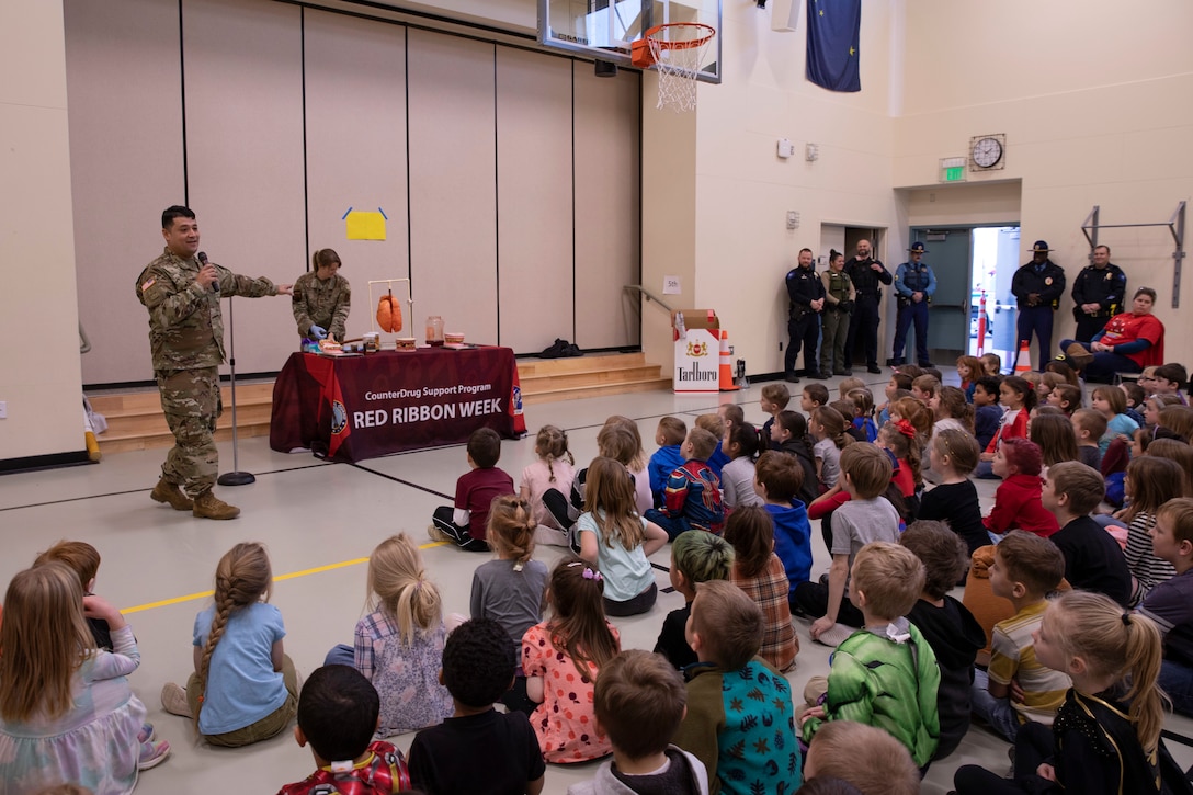 Alaska National Guard 1st Sgt. Oliver Meza, assigned to the Counterdrug Support Program, gives a presentation on Red Ribbon Week to the students of Iditarod Elementary in Wasilla, Alaska, Oct. 24, 2022. The Alaska National Guard collaborates with the Drug Enforcement Agency and local and state agencies in bolstering a sense of community and support in drug prevention awareness for Red Ribbon Week 2022. (Alaska National Guard photo by Victoria Granado)