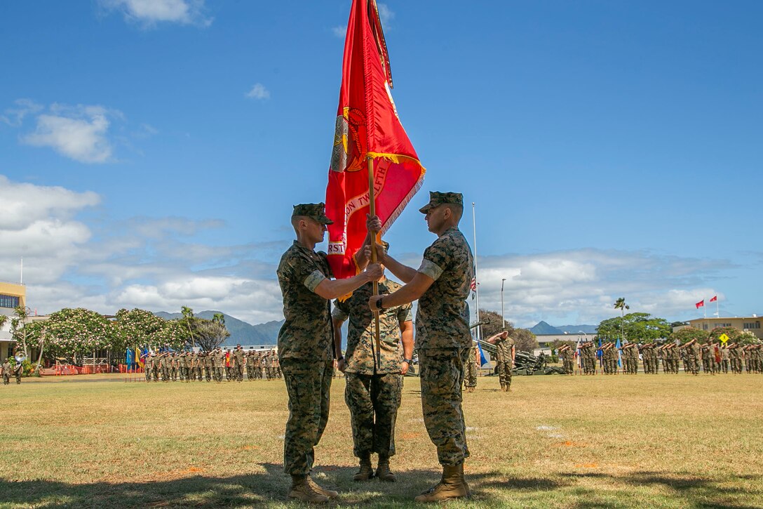 U.S. Marine Corps Lt. Col. Richard Neikirk, outgoing commanding officer, 1st Battalion, 12th Marine Regiment, passes the colors to Lt. Col. Joseph Gill II, incoming commanding officer, during the unit’s change of command ceremony on Marine Corps Base Hawaii, May 26, 2022. This tradition represents the passing of command from one leader to another. (U.S. Marine Corps photo by Sgt. Jacob Wilson)