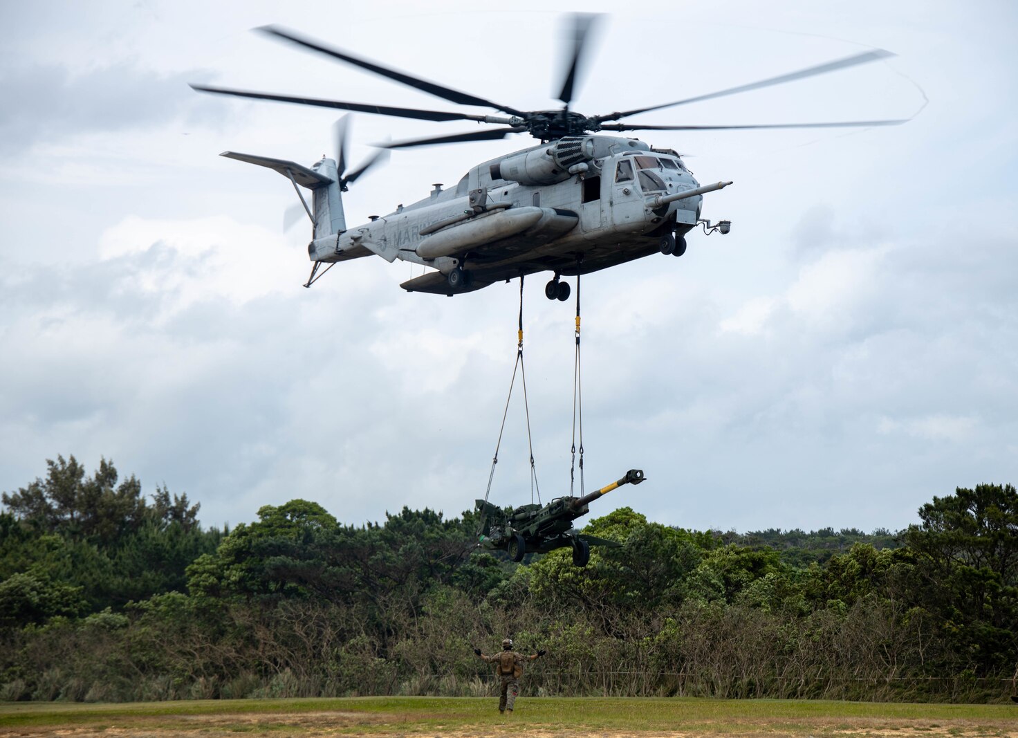 A CH-53 Sea Stallion with Heavy Marine Helicopter 466, 1st Marine Aircraft Wing, lifts an M77 howitzer during Helicopter Support Team training with Marines from  3rd Transportation Battalion, Combat Logistics Regiment 3 and 3rd Battalion, 12th Marine Regiment, 3rd Marine Division at Camp Hansen, Okinawa, Japan, Apr. 21, 2022.