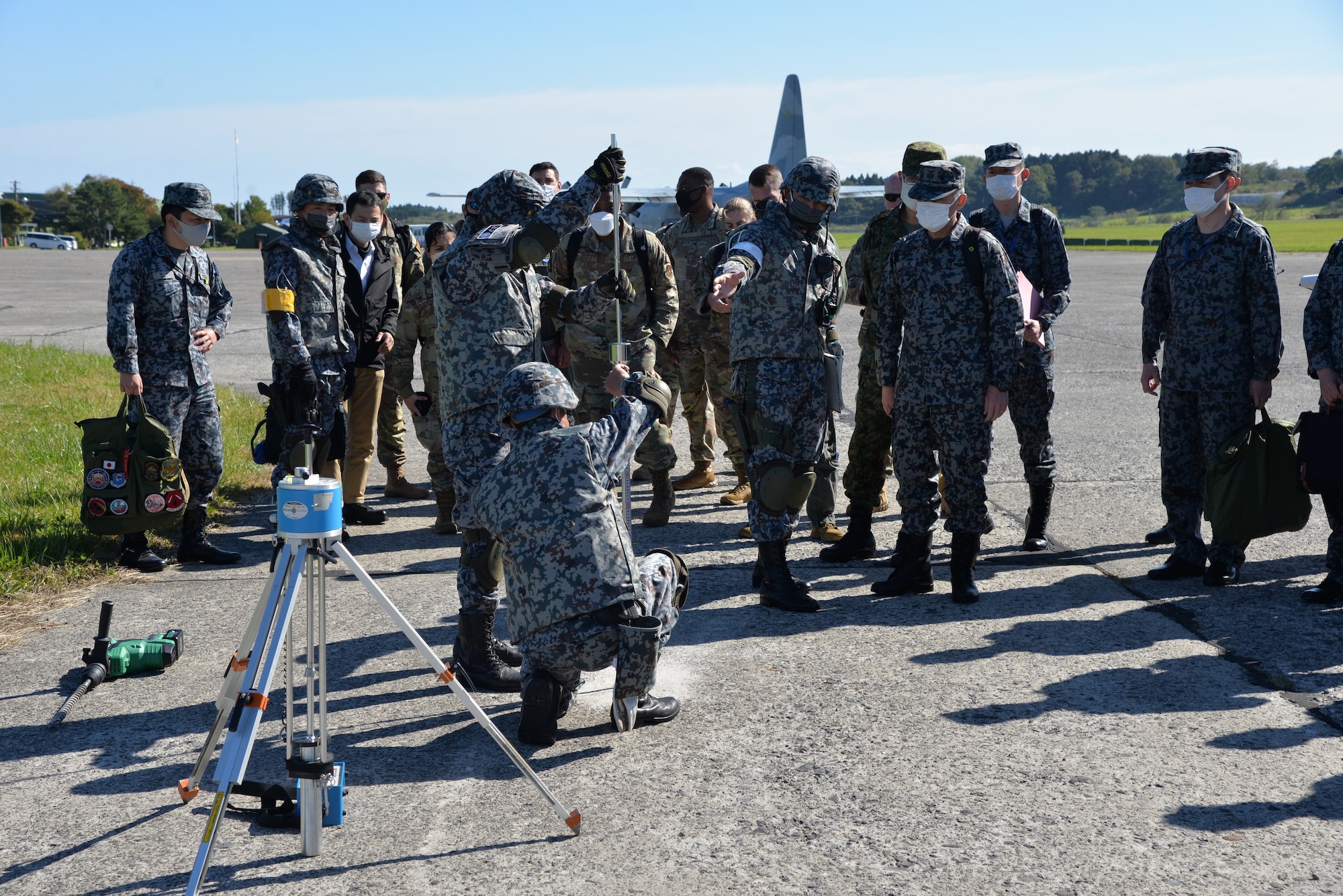 Members from 5th Air Force and the 515th Air Mobility Command watch as Japan Air Self-Defense Force (Koku Jieitai) survey the runway surface at Yakumo Sub Base, Japan, Oct. 13, 2022. U.S. service members went to Yakumo Sub Base to observe part of an exercise and see how they can coordinate better with JASDF during bilateral exercises. (Courtesy photo from JASDF)