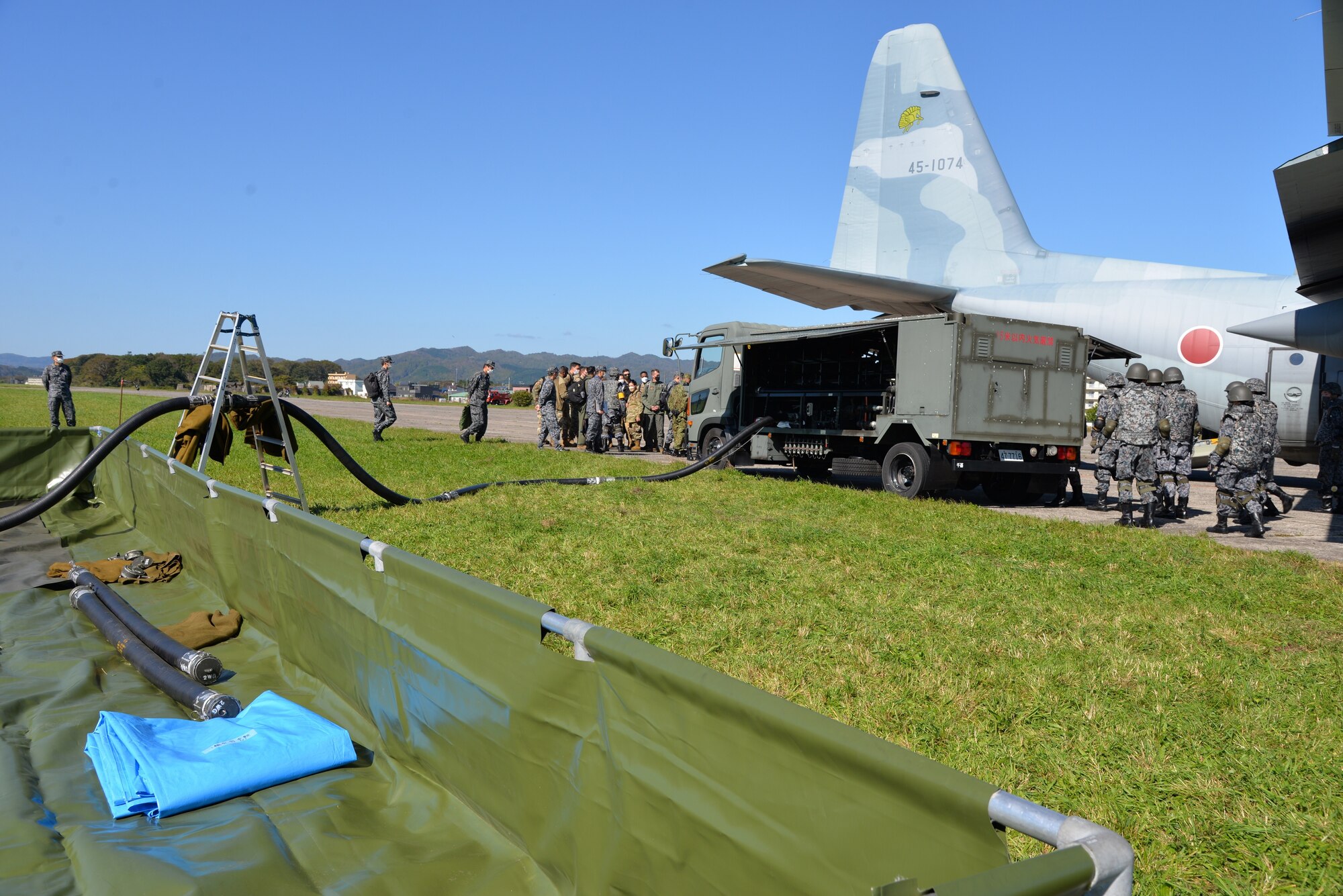Members from 5th Air Force and the 515th Air Mobility Command watch as Japan Air Self-Defense Force (Koku Jieitai) simulate refueling an aircraft at Yakumo Sub Base, Japan, Oct. 13, 2022. U.S. service members went to Yakumo Sub Base to learn how to better integrate with JASDF during a real-world contingency. (Courtesy photo from JASDF)