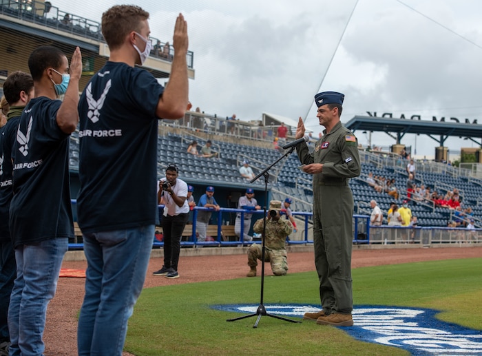 Rubio stands in front of group of Airmen to swear them into the Air Force, all members with their right hands raised as they repeat the oath.