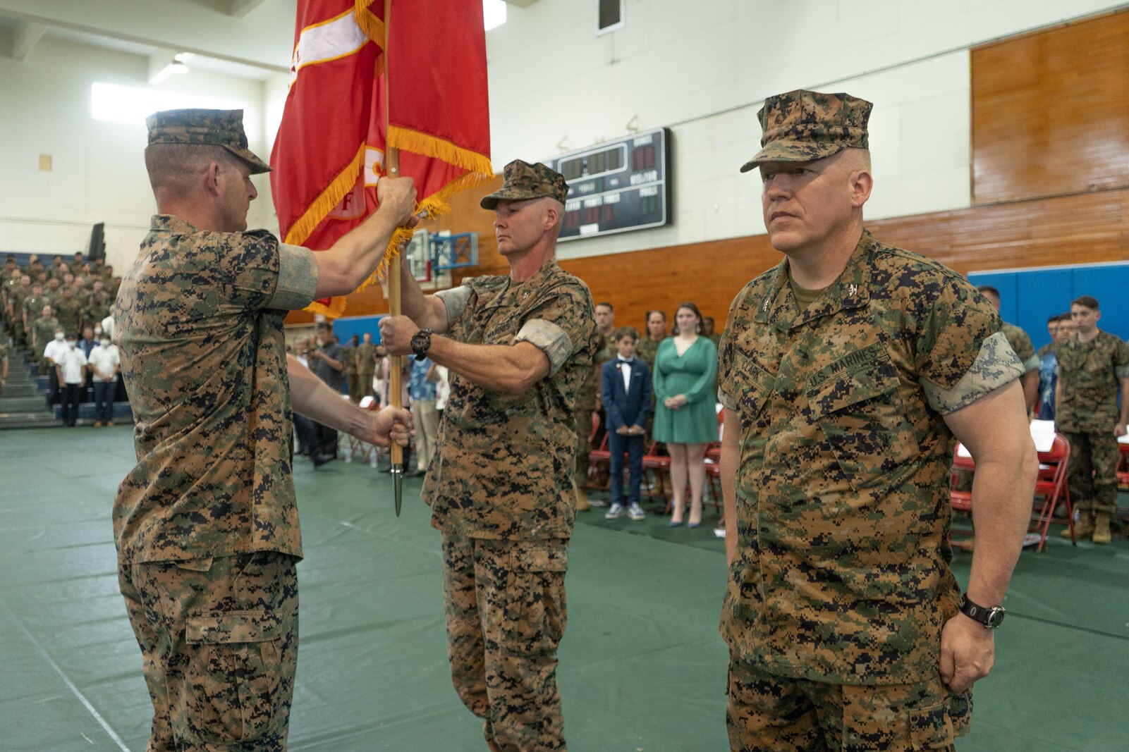 U.S. Marine Corps Col. Matthew Tracy, center, the outgoing commanding officer of 4th Marines, 3d Marine Division, receives the colors from Sgt. Maj. Christopher Singley, left, 4th Marines sergeant major, during a change of command ceremony on Camp Schwab, Okinawa, Japan, June 3, 2022.