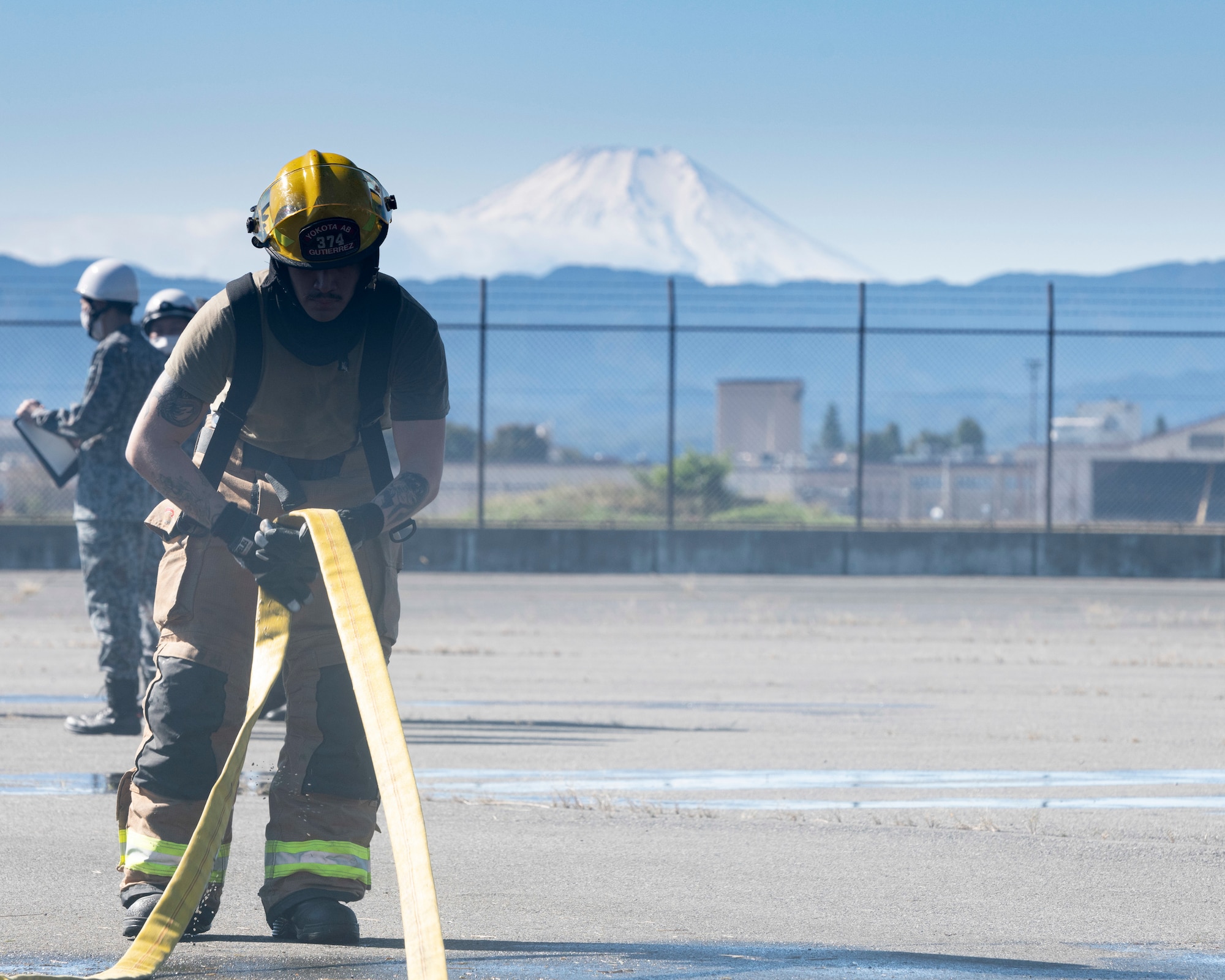 Airman 1st Class Kevin Gutierrez Gonzalez, 374th Civil Engineer Squadron firefighter, rolls up a fire hose after a bilateral training on an aircraft fire simulator at Yokota Air Base, Japan, Oct. 26, 2022.